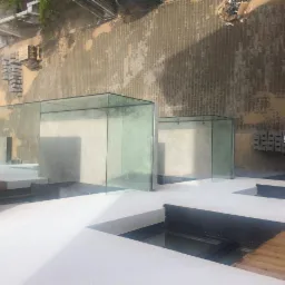 Szklane balustrady na tarasie z widokiem z góry, widoczne elementy montażowe i otoczenie placu budowy.