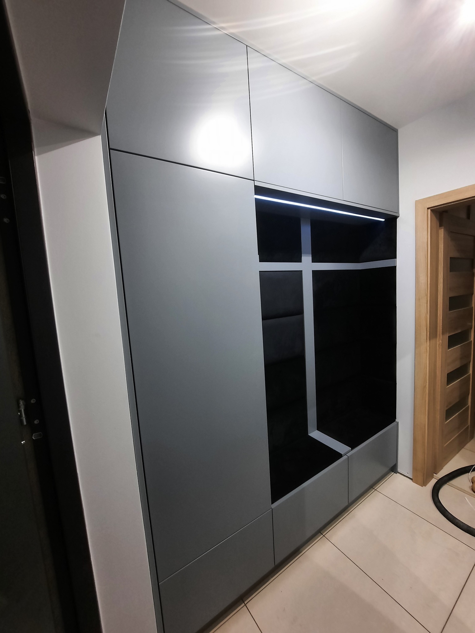 Szafa lakierowana z siedziskiem tapicerowanym.