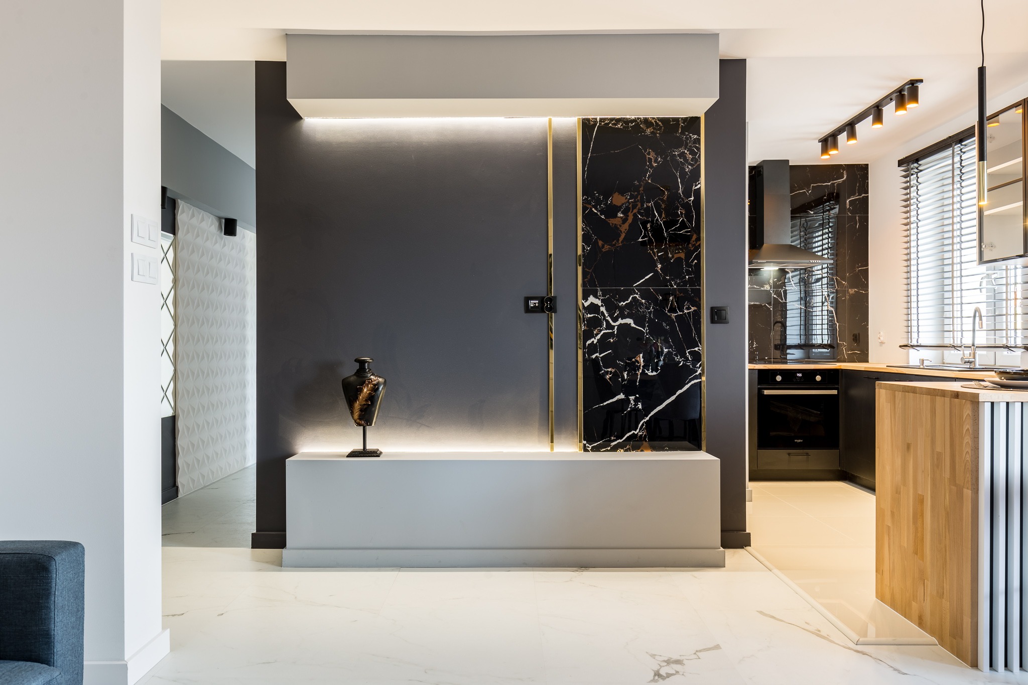 Sikorskiego. Ściana telewizyjna, czarne plytki 120x60, zlote listwy, nowa instalacja