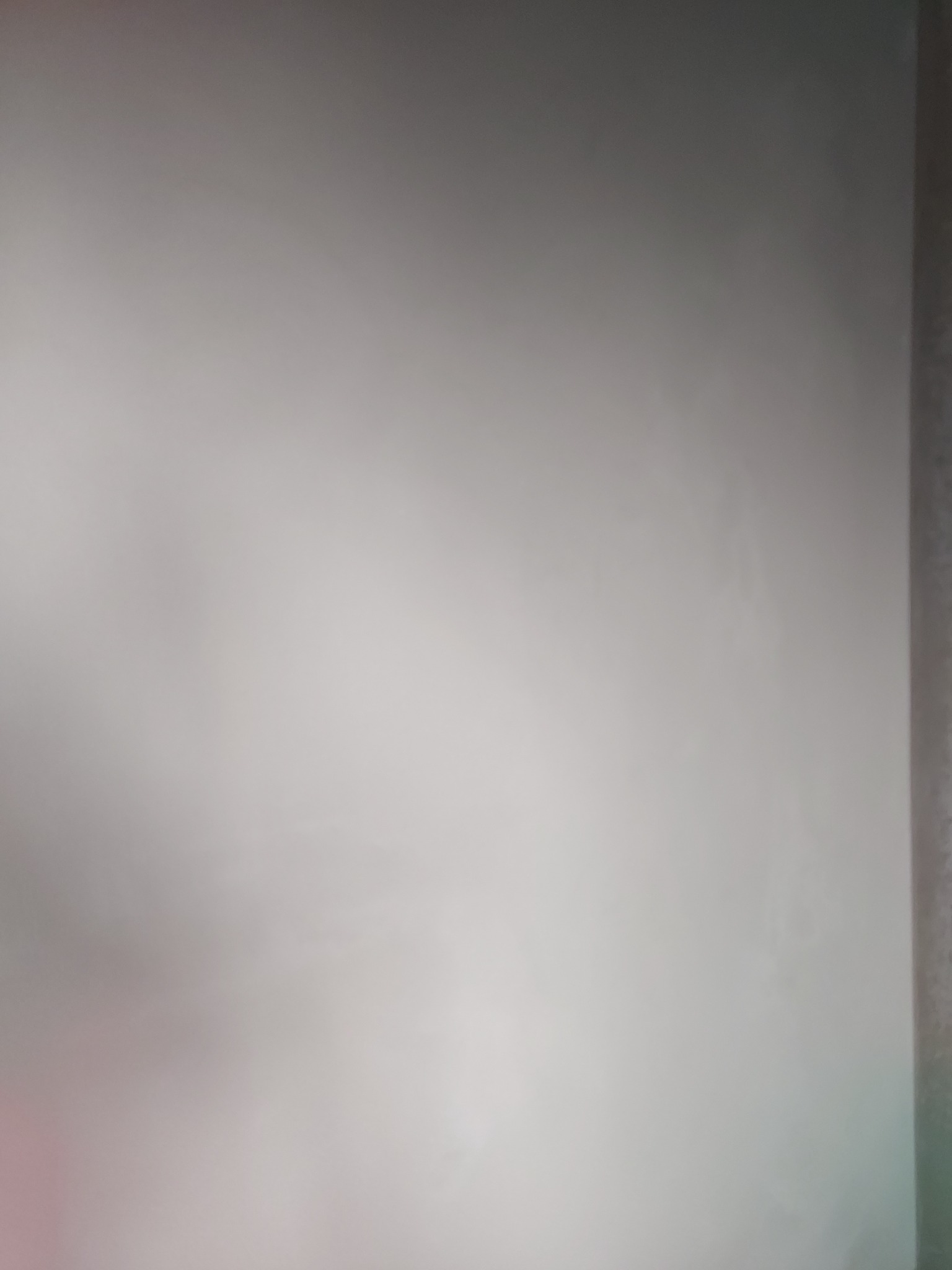 Świeżo pomalowana, gładka ściana w odcieniach szarości, z delikatnym gradientem światła.