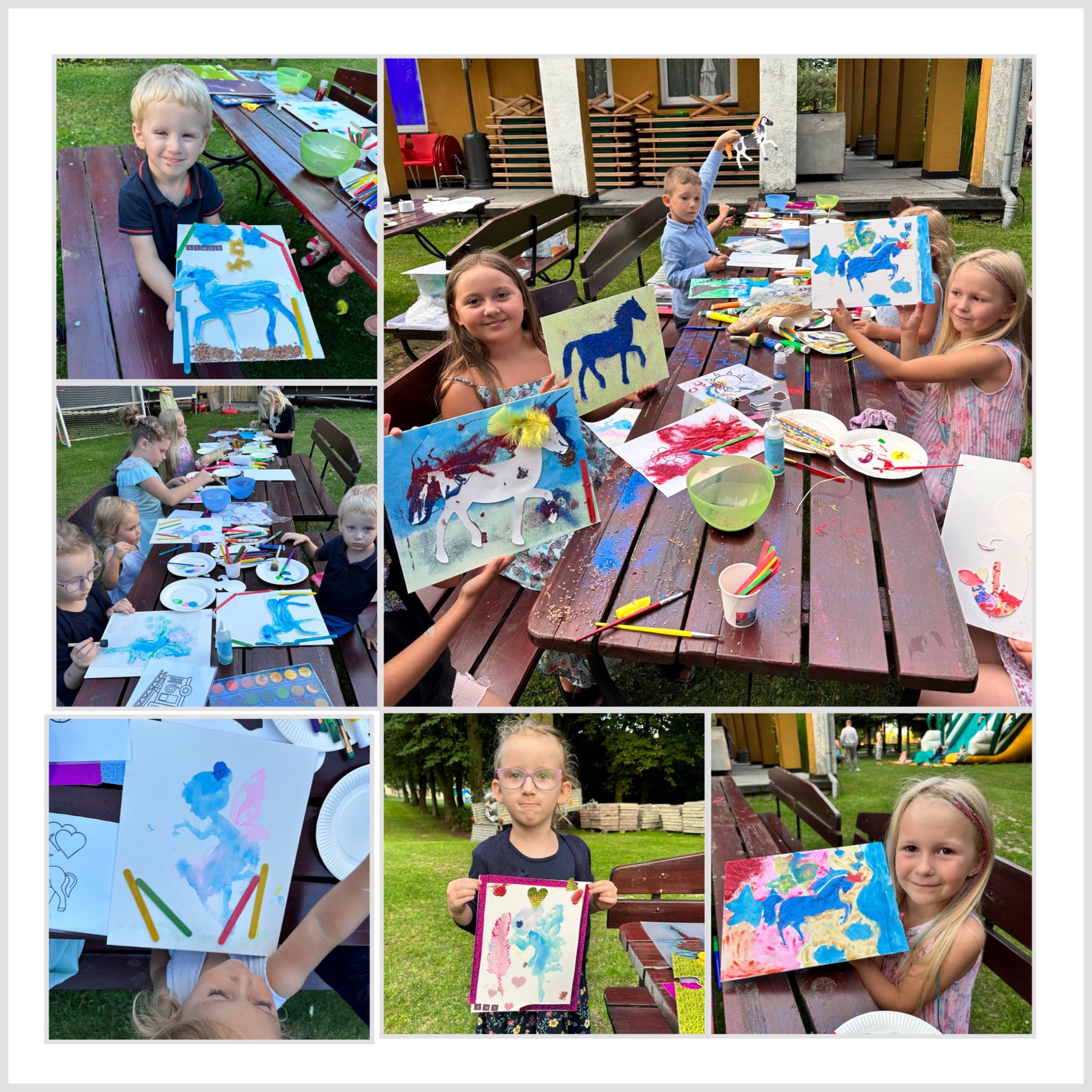 Grupa dzieci prezentuje samodzielnie wykonane prace plastyczne z motywem koni i jednorożców, wykorzystując farby, brokat i inne materiały dekoracyjne, podczas zajęć na świeżym powietrzu.