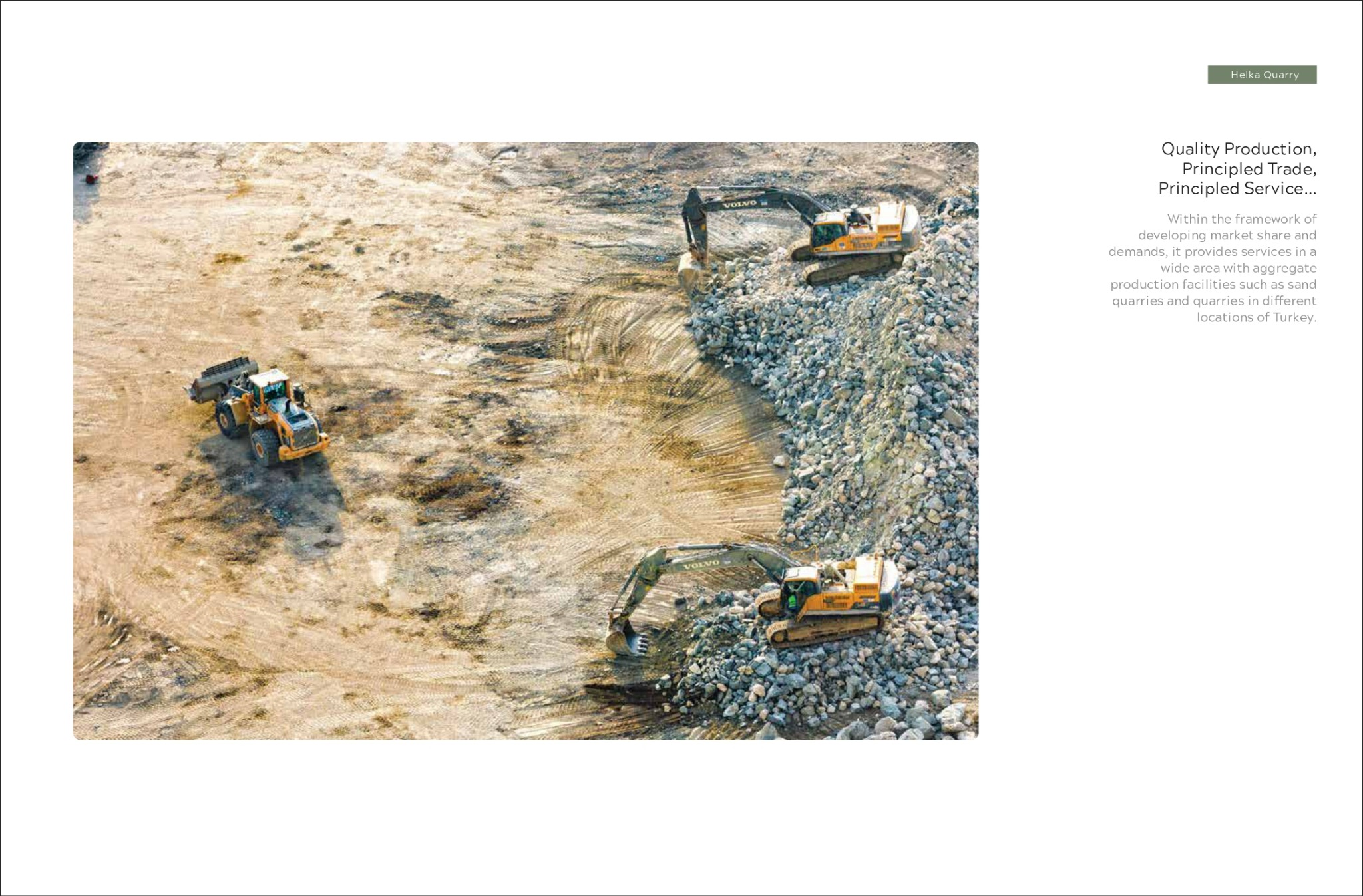 Widok z góry na plac budowy z pracującymi maszynami: ładowarka kołowa i dwie koparki Volvo, teren przygotowywany pod budowę.