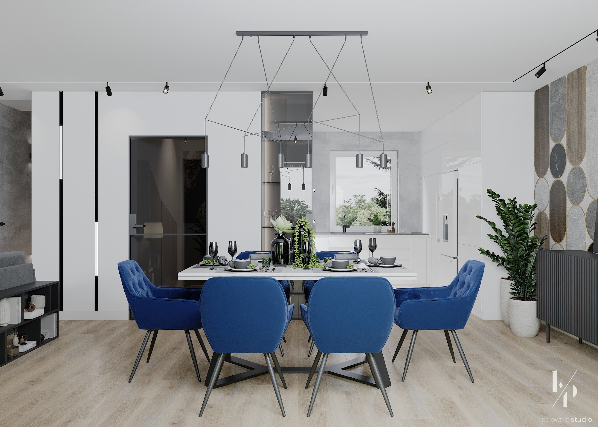 Nowoczesna jadalnia z białym stołem, aksamitnymi krzesłami w odcieniu kobaltu, wiszącą lampą o geometrycznym designie i widokiem na kuchnię w tle.