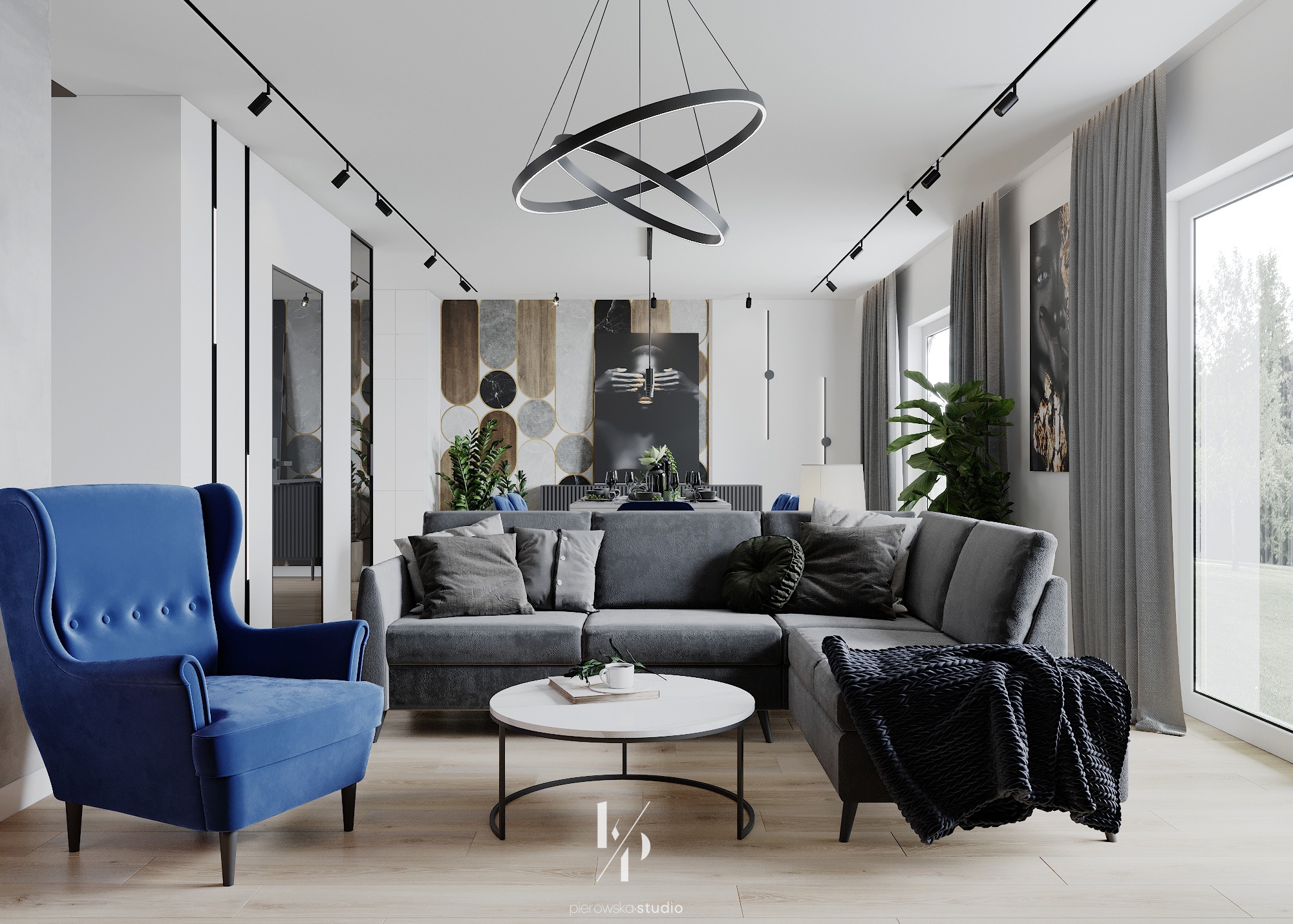 Nowoczesny salon z szarą sofą narożną, okrągłym stolikiem kawowym, niebieskim fotelem typu uszak i designerską lampą pierścieniową.