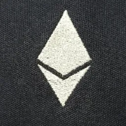 Czarny materiał z wyhaftowanym białym symbolem Ethereum.