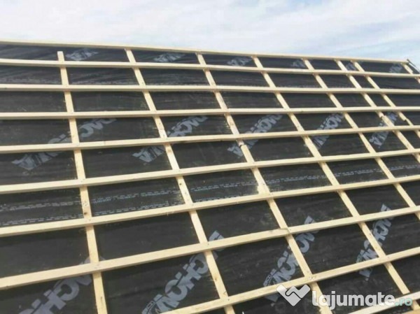 Konstrukcja drewniana dachu pokryta czarną membraną dachową z widocznym logo producenta, przygotowana pod montaż pokrycia dachowego.