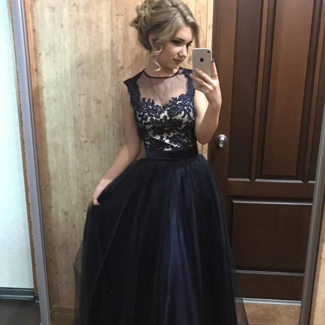 Blondynka robi selfie w lustrze, prezentując wieczorową suknię z koronkową górą i tiulowym dołem.