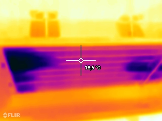 Termowizyjne zdjęcie grzejnika, wskazujące temperaturę 18,6°C, wykonane kamerą FLIR.