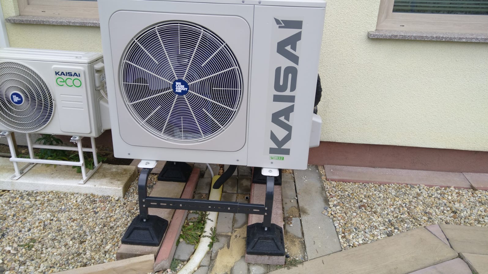 Dwie jednostki zewnętrzne klimatyzacji Kaisai, w tym model ECO, zainstalowane na posesji w Zgorzelcu, widoczne na tle elewacji i żwirowego podłoża.