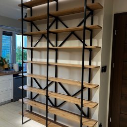 ACTUAL - Regał z drewnianymi półkami i czarną metalową konstrukcją, w tle widoczna kuchnia i okno.