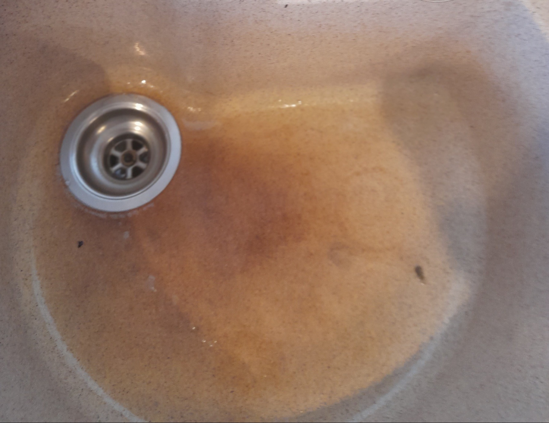 Zanieczyszczona umywalka z rdzawym osadem i widocznym odpływem w Gdańsku, wymagająca dokładnego czyszczenia.