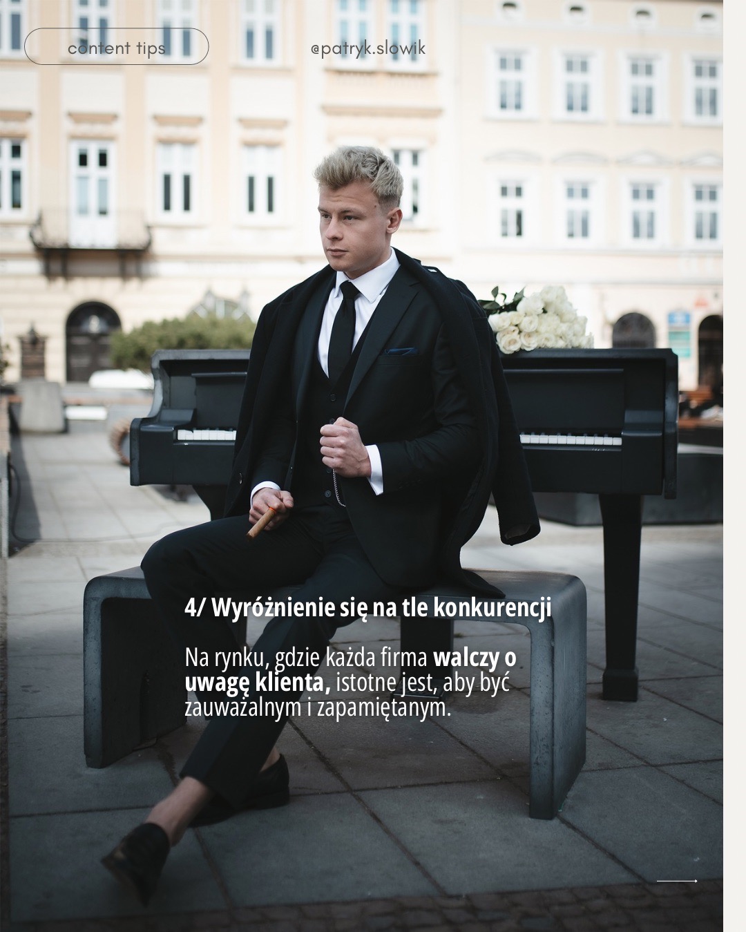 Mężczyzna w czarnym garniturze siedzi na betonowej ławce na tle budynku, trzymając cygaro; obok stoi czarny fortepian z bukietem białych róż.