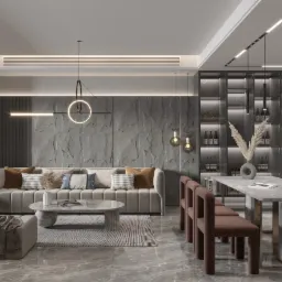 Nowoczesne wnętrze salonu z jadalnią, szara sofa z poduszkami, marmurowy stolik kawowy i stół z krzesłami w odcieniach brązu, na ścianie dekoracyjna okładzina imitująca kamień, oświetlenie punktowe...