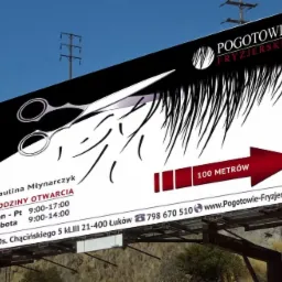 Billboard reklamujący salon fryzjerski Pogotowie Fryzjerskie z grafiką nożyczek i strzałką wskazującą kierunek, widoczne godziny otwarcia i dane kontaktowe.