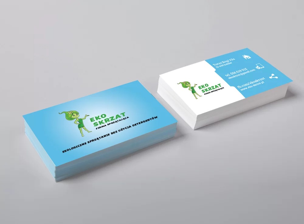 Dwa stosy wizytówek firmy Eko Skrzat, z logo przedstawiającym zielonego skrzata z kwiatem we włosach, informujące o ekologicznym sprzątaniu bez detergentów.