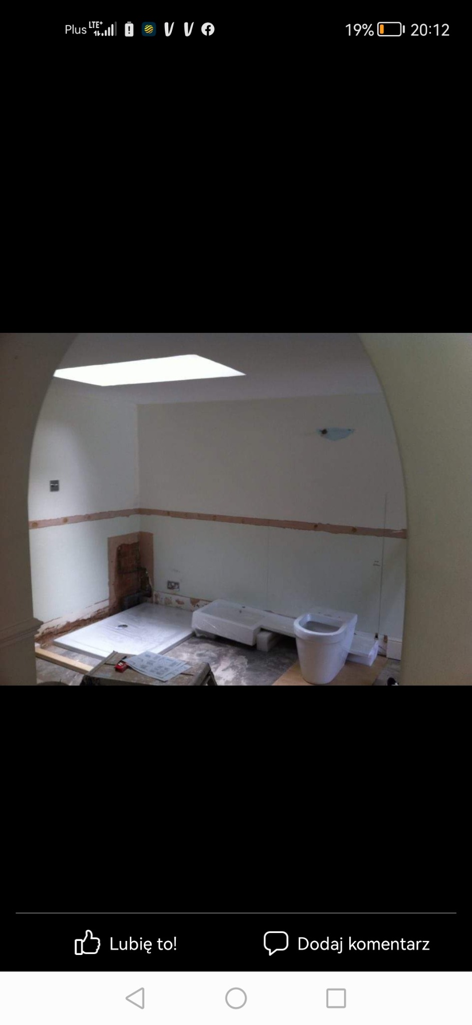 Łazienka w trakcie remontu: przygotowane ściany, zamontowany brodzik, obok stojąca w folii umywalka i toaleta.