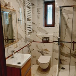 Remont łazienki wraz z przesunięciem ściany, skuciem, wykonaniem wylewki i przeróbek hydraulicznych. Kafle cięte na 45 stopni