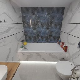 MD-BUD - Nowoczesna łazienka z wanną obudowaną płytkami imitującymi marmur, akcentem w postaci ciemnych płytek z motywem liści nad wanną, drewnianym blatem pod umywalką i podświetleniem LED pod wanną.