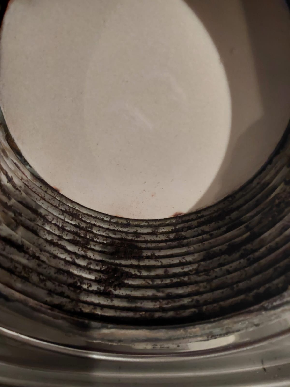 Wnętrze zanieczyszczonego przewodu kominowego z widocznymi osadami sadzy na ściankach.