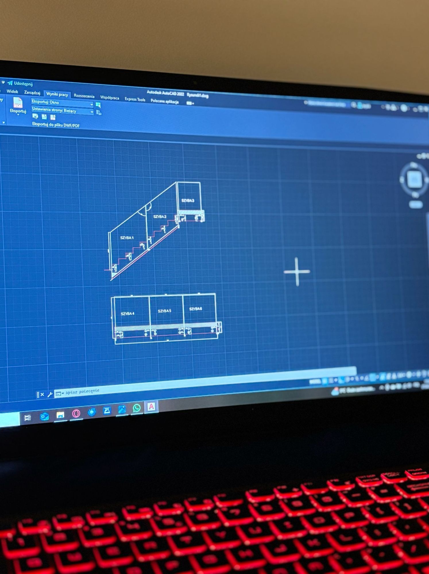 Ekran laptopa wyświetlający projekt w programie AutoCAD, prawdopodobnie rysunek techniczny szklanej balustrady schodowej z podziałem na szyby, widoczna klawiatura z czerwonym podświetleniem.