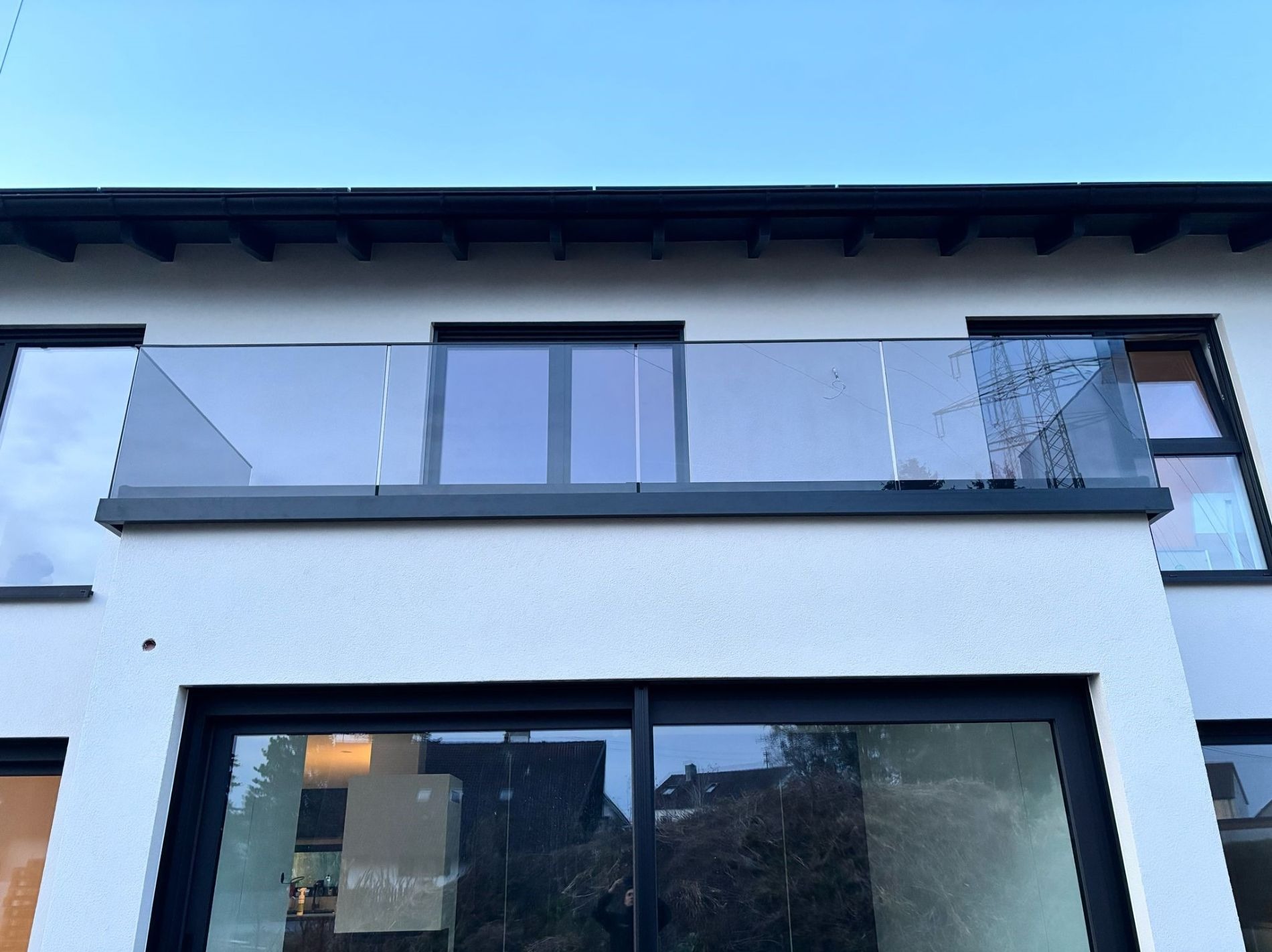 Balustrada całoszklona montowana od boku w profilu malowanym na RAL9005, ze szkłem grafitowym