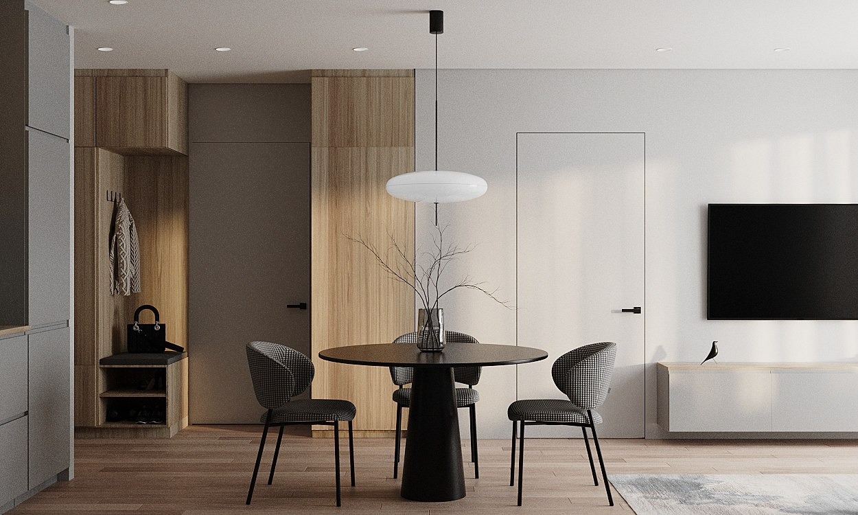 Nowoczesne wnętrze jadalni z okrągłym, czarnym stołem, trzema krzesłami w pepitkę, minimalistyczną lampą wiszącą i dekoracyjnymi gałązkami w szklanym wazonie.