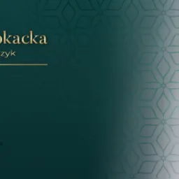 Portret uśmiechniętej adwokat Agnieszki Szymczyk na tle z logo kancelarii, ubrana w bluzkę w grochy, z założonymi rękami.