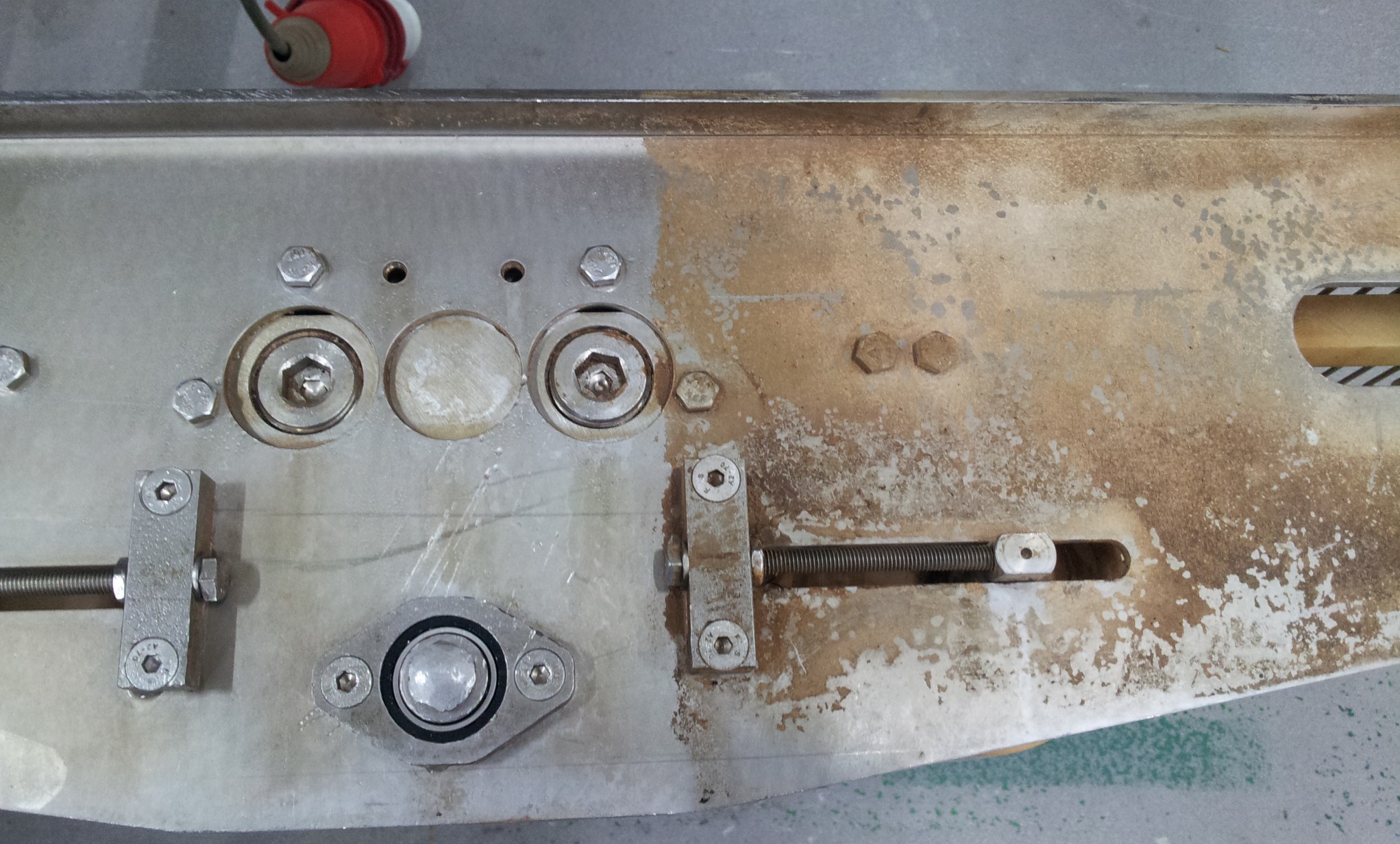 Częściowo wyczyszczona metalowa konstrukcja z widocznymi śladami zabrudzeń i różnicą w wyglądzie powierzchni po czyszczeniu, ukazująca proces usuwania zanieczyszczeń.