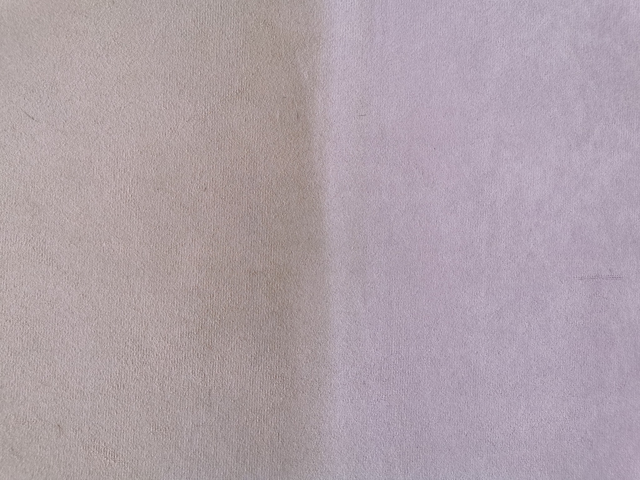 Połowa powierzchni tapicerki w kolorze brudnego różu po lewej stronie jest wyraźnie ciemniejsza i zabrudzona, natomiast prawa strona prezentuje efekt po czyszczeniu, ukazując jaśniejszy odcień...