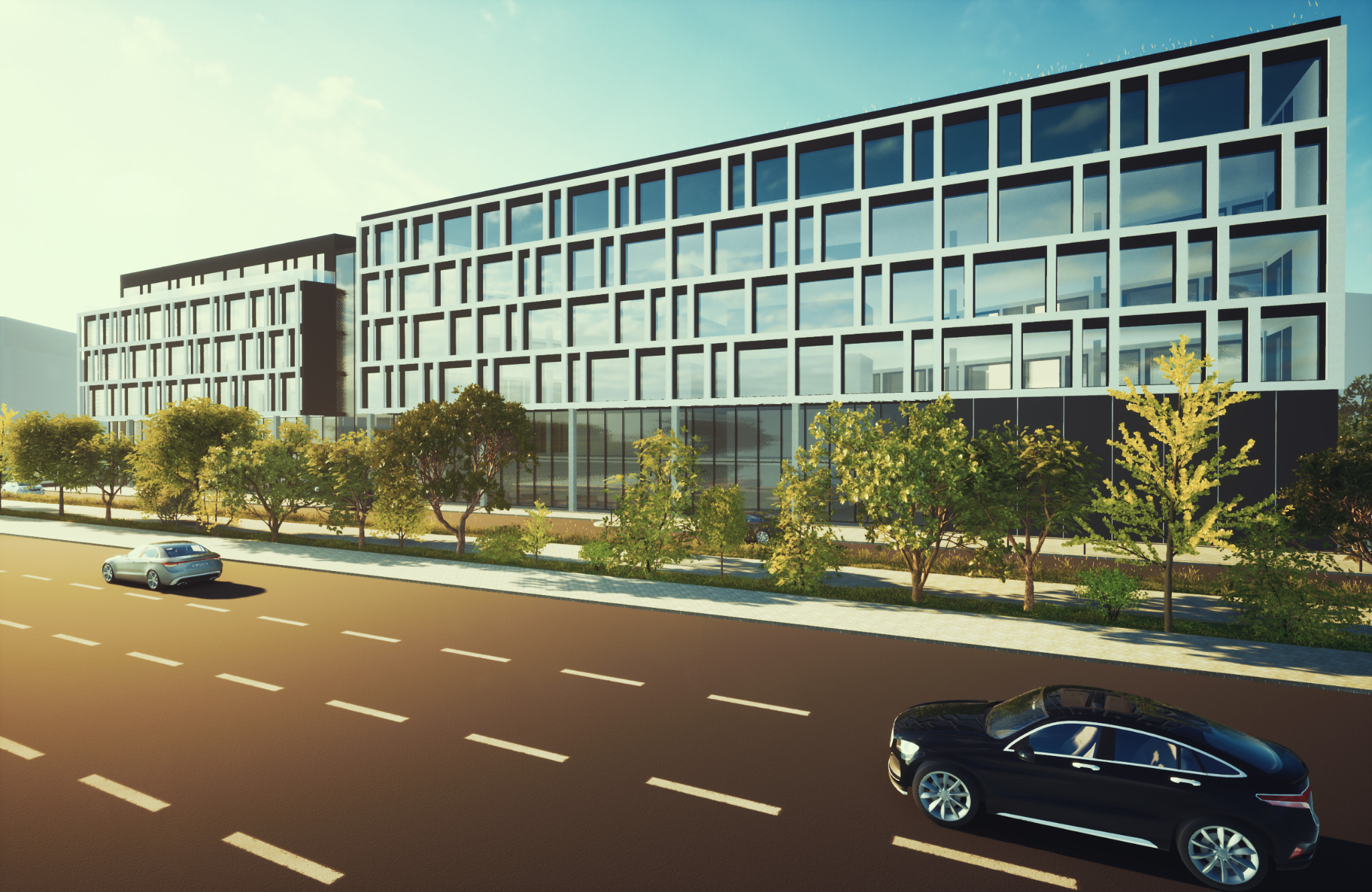 Nowoczesny budynek biurowy z białą elewacją i dużymi oknami, otoczony zielenią i ulicą z samochodami w słoneczny dzień.