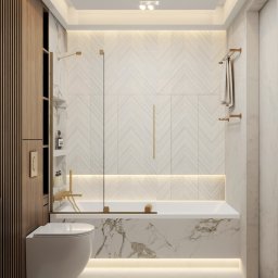Sirocco Studio Jakub Łaski - Elegancka łazienka z wanną obłożoną marmurem, armaturą w kolorze złota i wzorem jodełki na ścianie. Całość dopełnia nastrojowe oświetlenie LED.