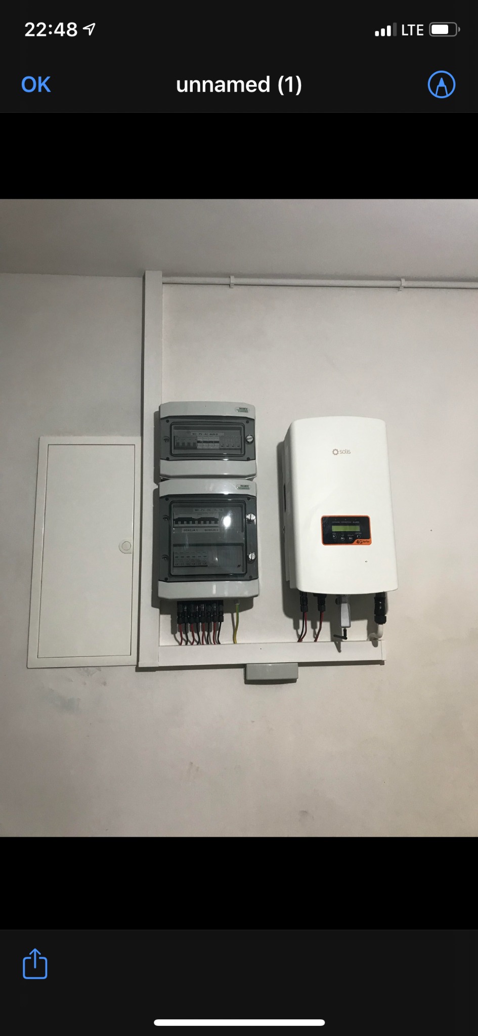 Solis falownik fotowoltaiczny i rozdzielnica elektryczna zamontowane na ścianie wewnątrz budynku, widoczne kable i przewody.