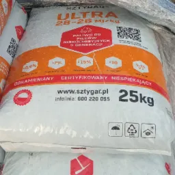 Stos worków z opałem marki Sztygar Ultra 28-26 MJ/kg, z widocznymi informacjami o parametrach i certyfikatach, zapakowanych w folię ochronną.