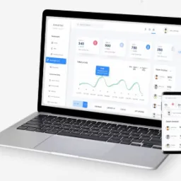 Laptop i smartfon prezentujące interfejs systemu do zarządzania z dashboardem, wykresami i danymi finansowymi, na jasnym tle.