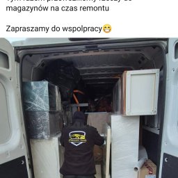 Stodulski trans - Wnętrze busa firmy Stodulski Trans załadowane meblami i przedmiotami zabezpieczonymi folią stretch, widok z tyłu na pracownika w bluzie z logo firmy.