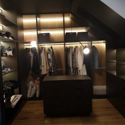 Dmytro Abramchuk - Czarna garderoba w zabudowie z oświetleniem LED, drewnianą podłogą i komodą z ciemnego kamienia