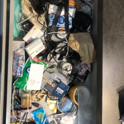 Cleaning Time - Niejednolity bałagan w szufladzie: maseczki ochronne, kable, ładowarki, chusteczki higieniczne, opakowania po lekach, taśma klejąca i inne drobiazgi.