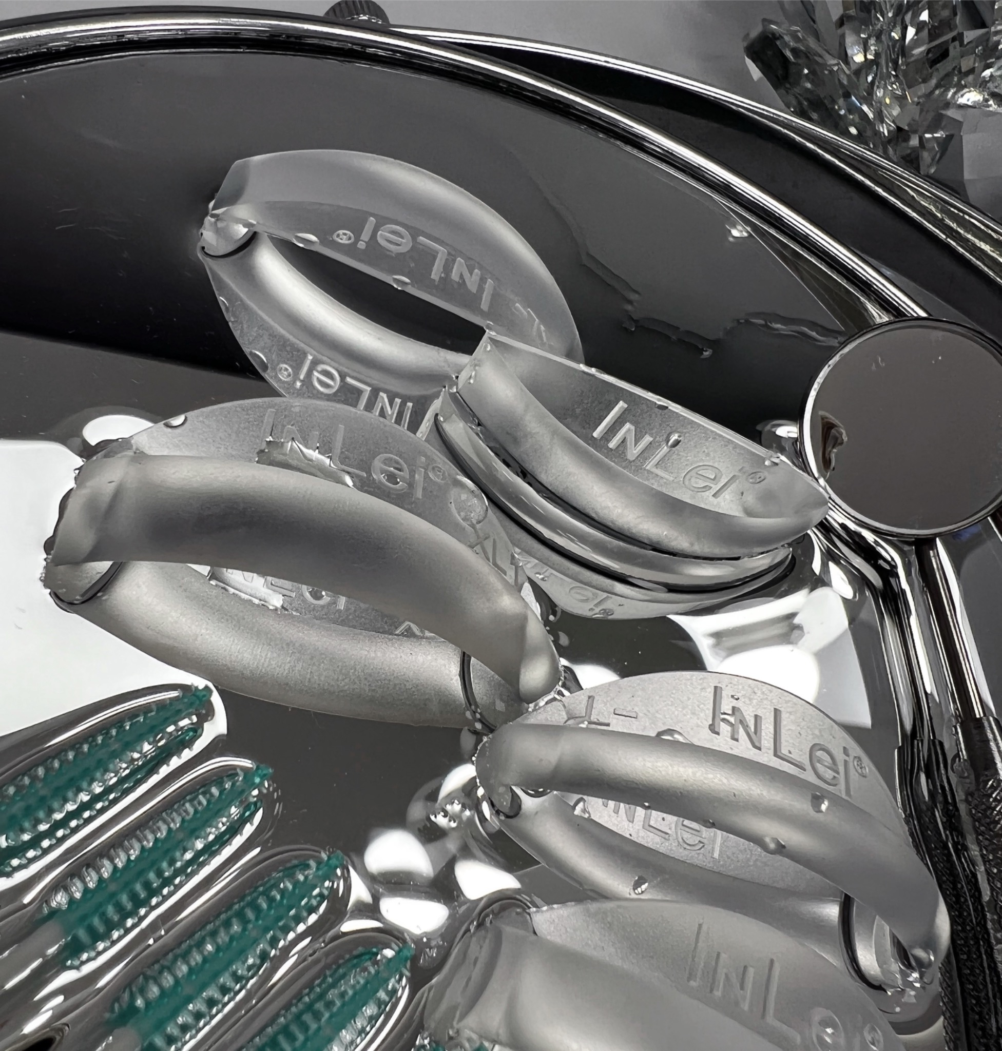 Stomatologiczne narzędzia i akcesoria marki InLei w sterylizatorze, widoczne szczoteczki i lusterko dentystyczne.