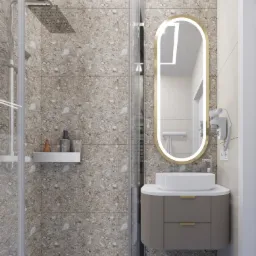 Nowoczesna łazienka z kabiną prysznicową wyłożoną płytkami imitującymi kamień, owalne lustro z podświetleniem LED, umywalka nablatowa na szafce z szufladami w kolorze taupe oraz akcesoria...