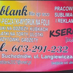 Żółto-czerwona ulotka reklamowa firmy Leblank z Suchedniowa, oferującej nadruki na odzieży, banery, wizytówki, ulotki i ksero, leżąca na ciemnej, tekstylnej powierzchni.
