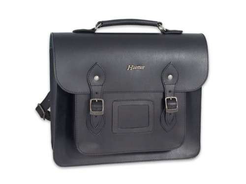 Czarna, skórzana torba typu listonoszka z metalowymi sprzączkami i uchwytem, widoczne logo producenta 'Huetter' nad kieszenią, na białym tle.