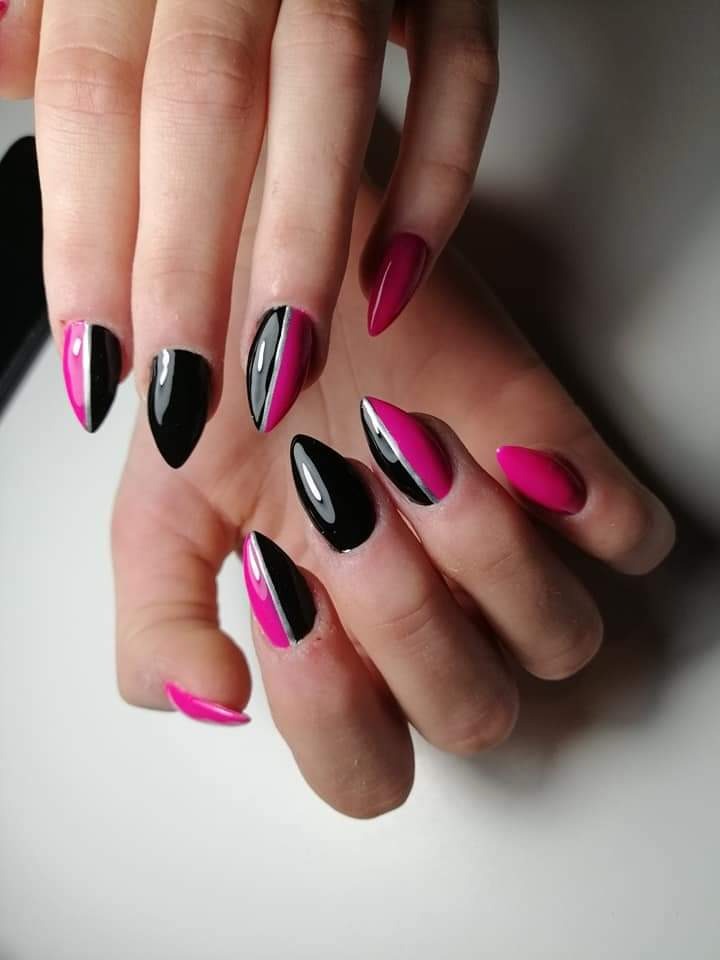 Dłoń z paznokciami pomalowanymi w Radomsku, z połową w kolorze czarnym i połową w kolorze fuksji, oddzielone cienką srebrną linią, na białym tle.