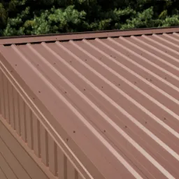 Nowoczesny budynek gospodarczy z brązowym dachem z profilowanej stali, widok z góry na regularny układ mocowań.