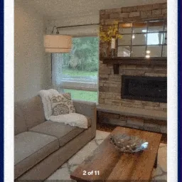 Wirtualny spacer po salonie z beżową sofą, kominkiem obłożonym kamieniem i drewnianym stolikiem kawowym, widoczne okno z widokiem na zieleń, na dole rzut mieszkania z zaznaczonym salonem.