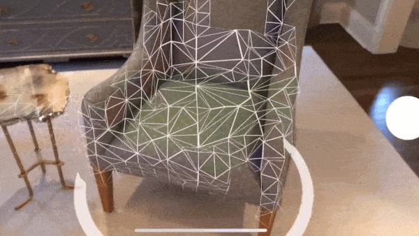 Wizualizacja 3D fotela w pokoju z nałożoną siatką trójkątów, prezentowana jako model interaktywny z elementami interfejsu użytkownika.