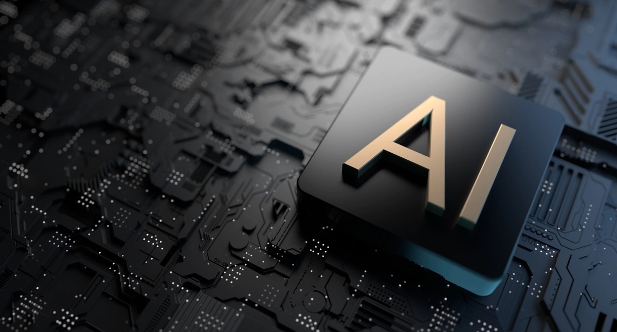 Złoty napis AI na czarnym, błyszczącym kwadracie, umieszczonym na tle ciemnej, matowej płyty głównej z widocznymi ścieżkami i punktami lutowniczymi.