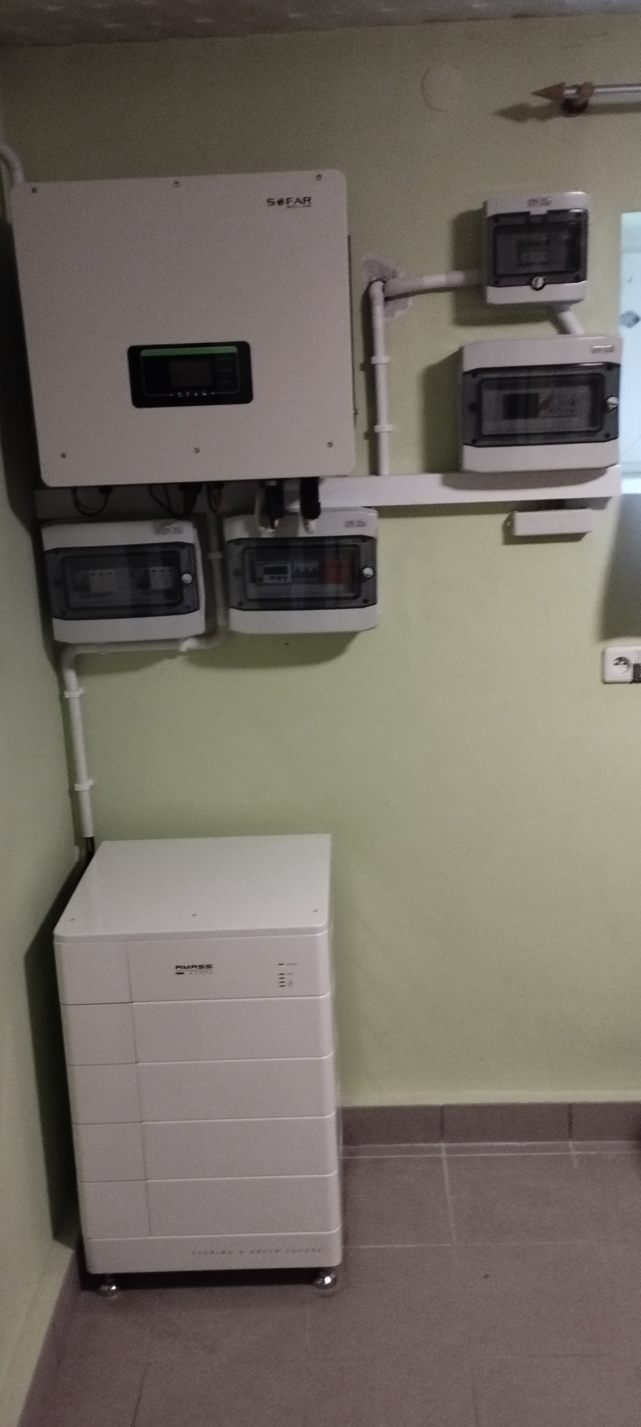 Zamontowana instalacja fotowoltaiczna w pomieszczeniu technicznym: inwerter Sofar, moduł bateryjny Pylontech oraz skrzynki zabezpieczeń na ścianie.