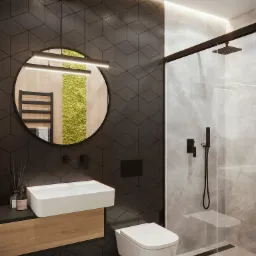 Nowoczesna łazienka z czarnymi heksagonalnymi płytkami, okrągłym lustrem z podświetleniem LED, białą umywalką nablatową, wiszącą toaletą i kabiną prysznicową ze szklaną ścianą i czarnymi ramami.