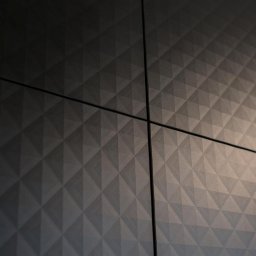 ASPEKT meble - Ciemnoszara, teksturowana powierzchnia szafy z geometrycznym wzorem trójkątów, widoczne łączenia płyt i logo producenta w prawym dolnym rogu.