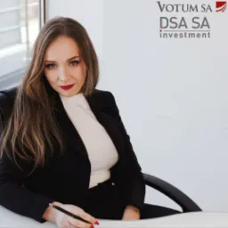 Kobieta w czarnym żakiecie siedzi przy biurku i pisze, w tle logo firmy Votum DSA SA investment.